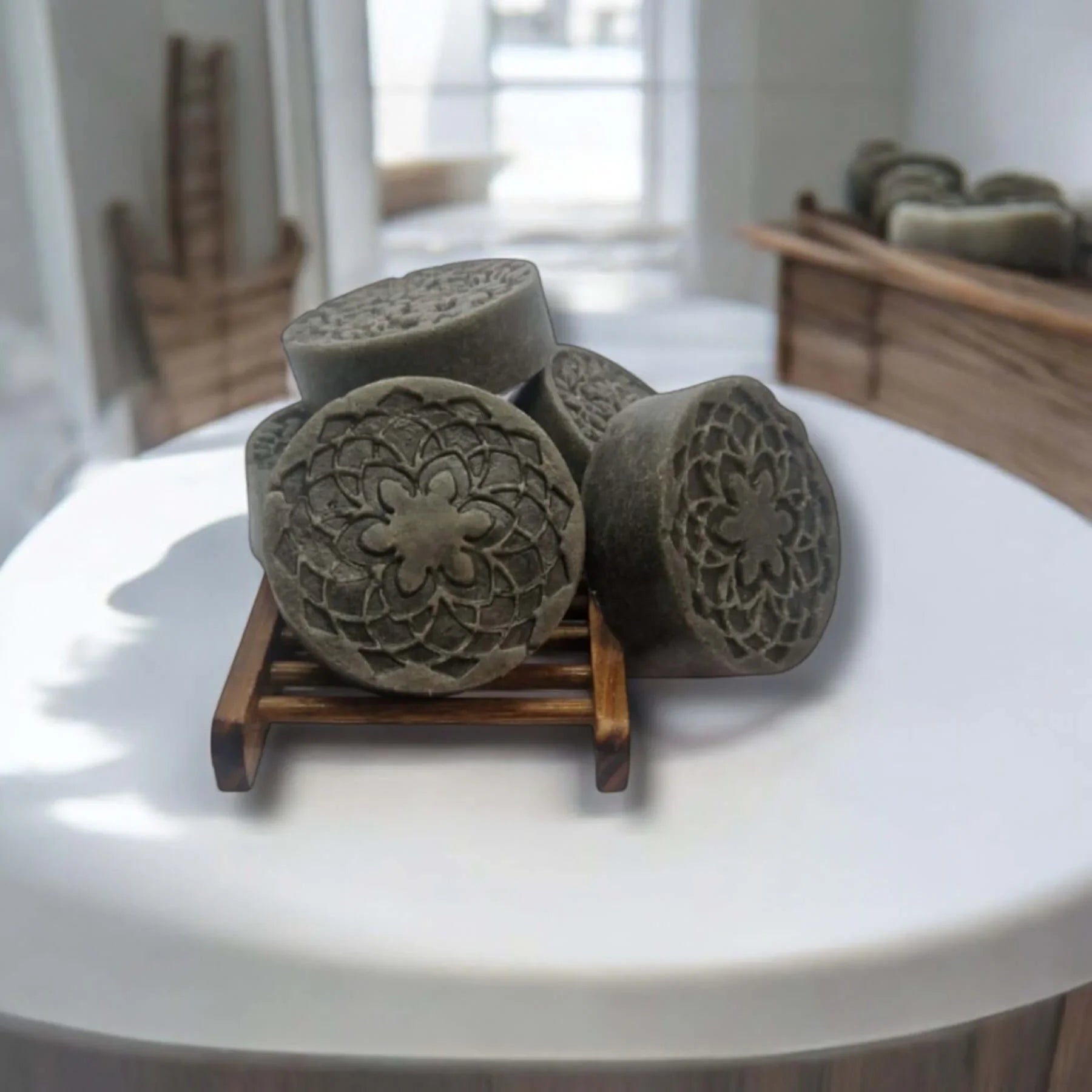 African Black Soap bars with a decorative design, displayed on a wooden stand, showcasing their cleansing properties.