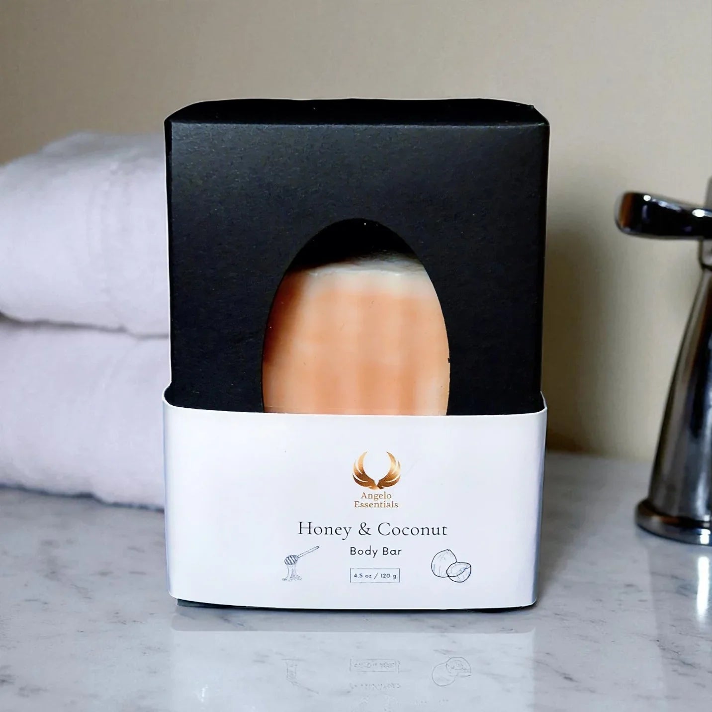 Honey & Coconut Soap bar in elegant black packaging on a marble surface, showcasing natural ingredients for skin nourishment.